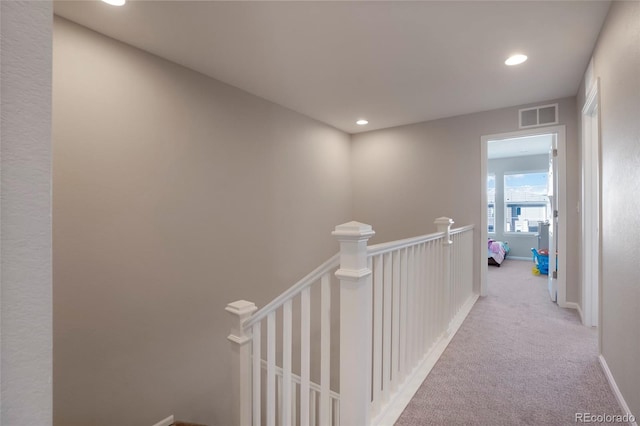 hall featuring visible vents, light carpet, an upstairs landing, and recessed lighting