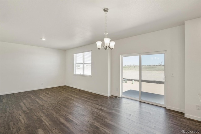 unfurnished room with dark hardwood / wood-style flooring and an inviting chandelier