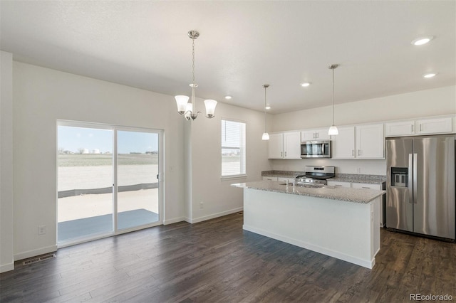 kitchen featuring appliances with stainless steel finishes, decorative light fixtures, white cabinetry, and an island with sink