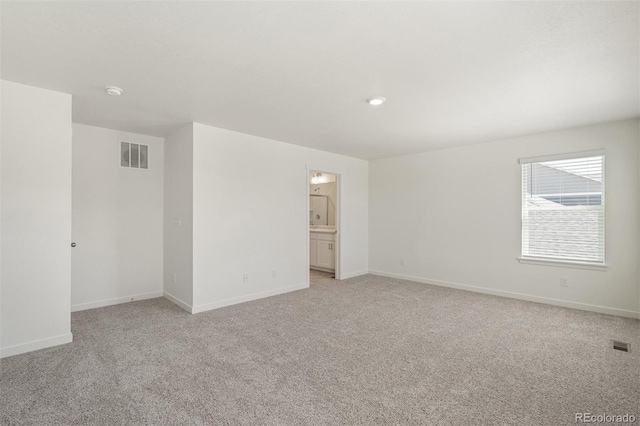 spare room featuring light colored carpet