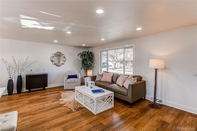 living area with recessed lighting, baseboards, and wood finished floors