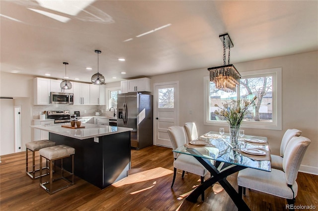 kitchen with white cabinets, appliances with stainless steel finishes, light countertops, and a center island