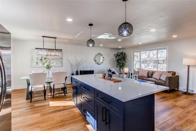 kitchen with blue cabinets, light wood-style floors, light countertops, and recessed lighting