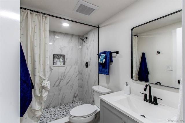 full bath with toilet, vanity, a tile shower, and visible vents