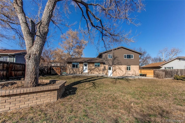 back of property with a yard and a fenced backyard