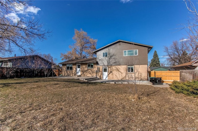 back of property with a patio area, fence, and a lawn