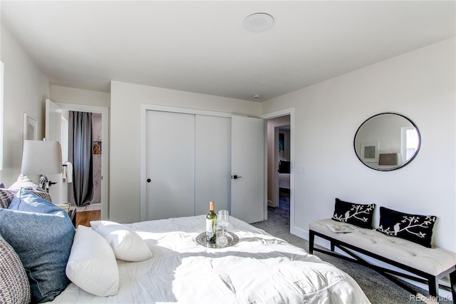 carpeted bedroom featuring a closet and baseboards