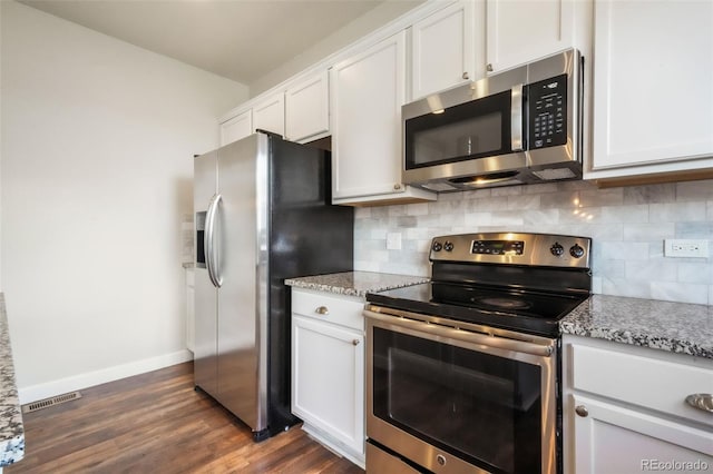 kitchen featuring baseboards, dark wood-type flooring, white cabinets, tasteful backsplash, and stainless steel appliances