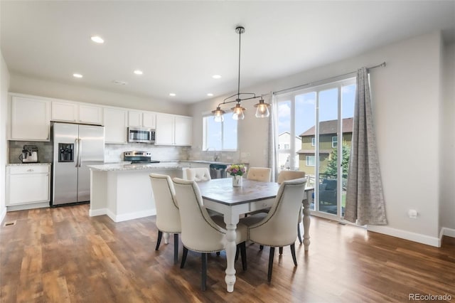 dining room with baseboards, recessed lighting, and wood finished floors