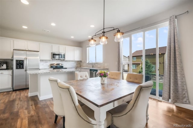 dining space featuring recessed lighting and dark wood-style floors