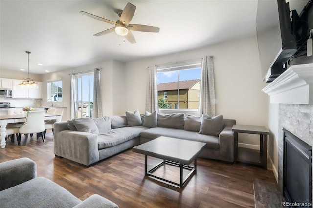 living area with recessed lighting, ceiling fan, a fireplace, and dark wood finished floors