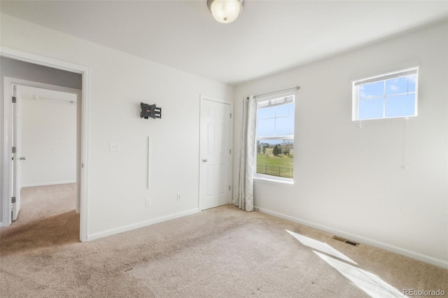 unfurnished bedroom with baseboards, carpet flooring, and visible vents
