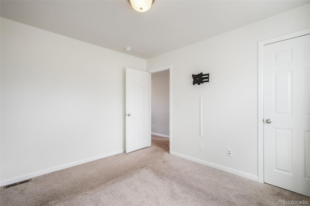 unfurnished bedroom with visible vents, carpet flooring, and baseboards
