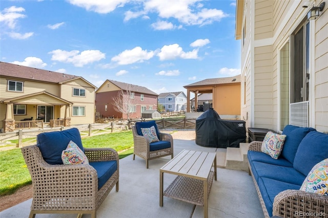 view of patio / terrace with fence, an outdoor living space, and a residential view