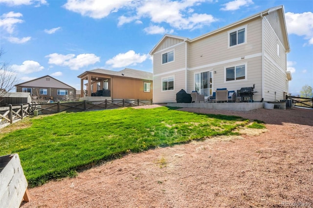 rear view of house featuring a yard, board and batten siding, a fenced backyard, and a patio area