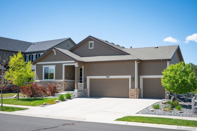 18067 E Anthem Dr, Parker, CO 80134 - craftsman-style home featuring an attached garage, stone siding, driveway, and roof with shingles