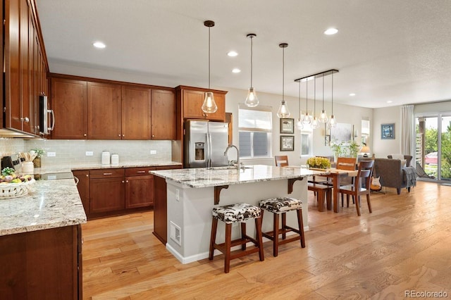 18067 E Anthem Dr, Parker, CO 80134 - kitchen with stainless steel appliances, light wood-style floors, a sink, backsplash, and recessed lighting