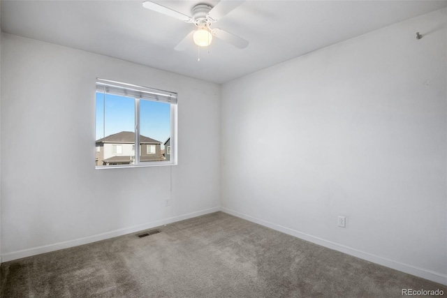 spare room with ceiling fan and carpet