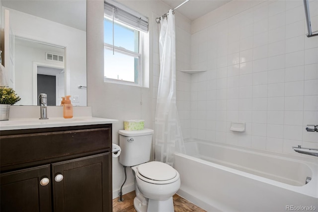 full bathroom with hardwood / wood-style flooring, vanity, shower / bath combination with curtain, and toilet