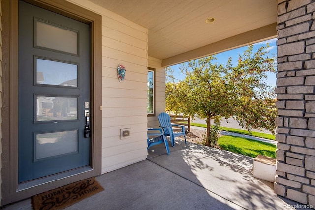 view of exterior entry featuring covered porch