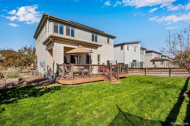 rear view of property with a wooden deck and a yard