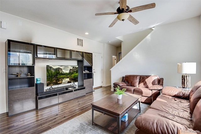 living room featuring dark wood-type flooring and ceiling fan