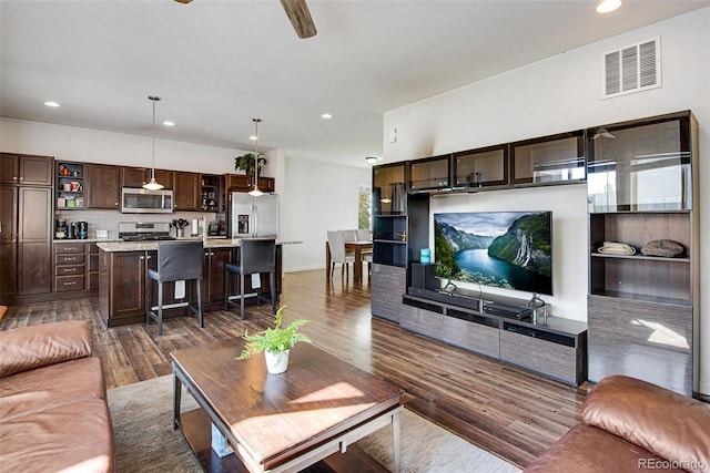 living room featuring dark wood-type flooring and ceiling fan