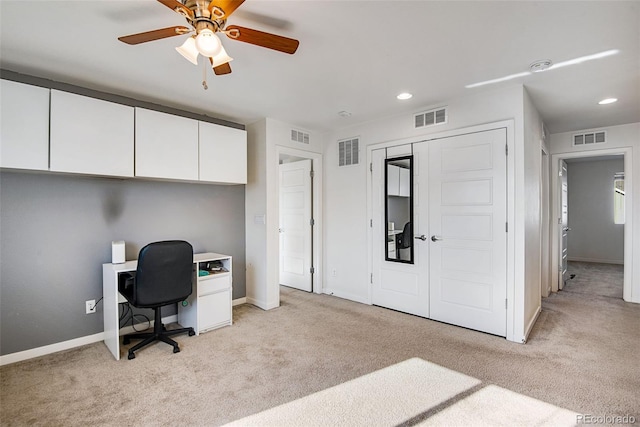 carpeted office space featuring ceiling fan