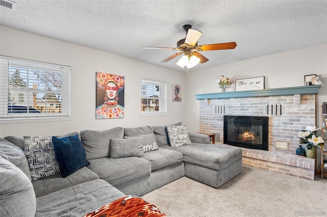 living room with a fireplace, a textured ceiling, and a wealth of natural light