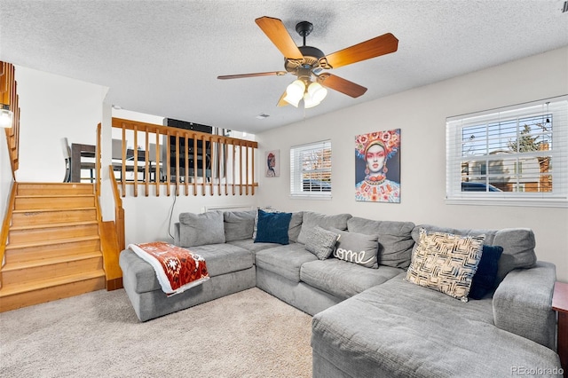 carpeted living room with ceiling fan, a healthy amount of sunlight, and a textured ceiling