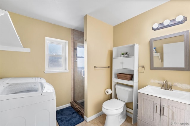 bathroom featuring vanity, a shower with door, tile patterned flooring, toilet, and washing machine and dryer