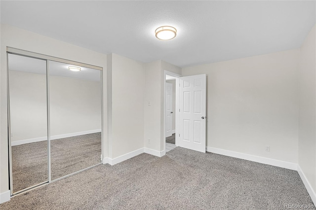 unfurnished bedroom with a textured ceiling, carpet flooring, and a closet