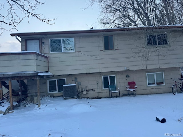 snow covered property with central AC