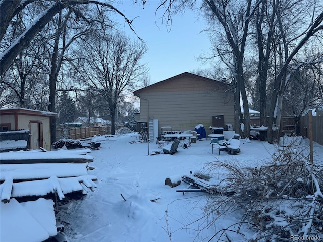 view of snowy exterior featuring a shed