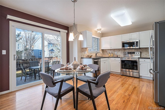 dining area with sink and light wood-type flooring