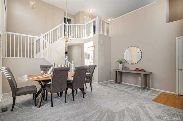 dining area with a high ceiling, a chandelier, and carpet