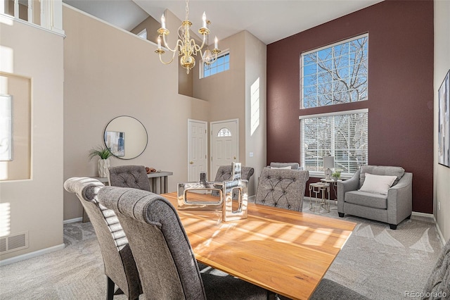 carpeted dining space featuring a chandelier and a high ceiling