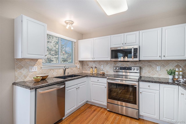 kitchen with white cabinetry, sink, tasteful backsplash, and appliances with stainless steel finishes