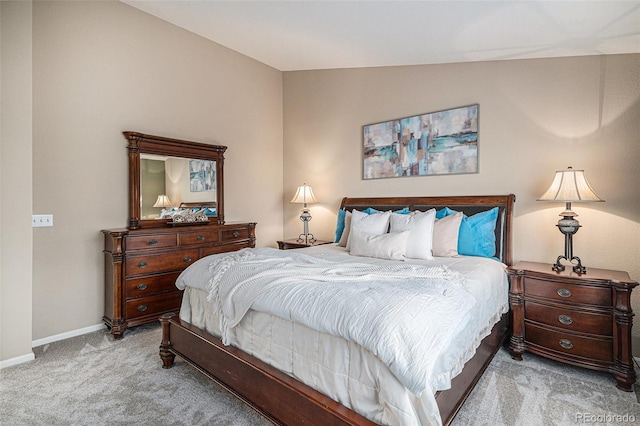 bedroom featuring lofted ceiling and light carpet