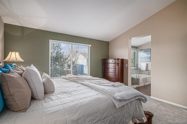 bedroom with connected bathroom, vaulted ceiling, and carpet