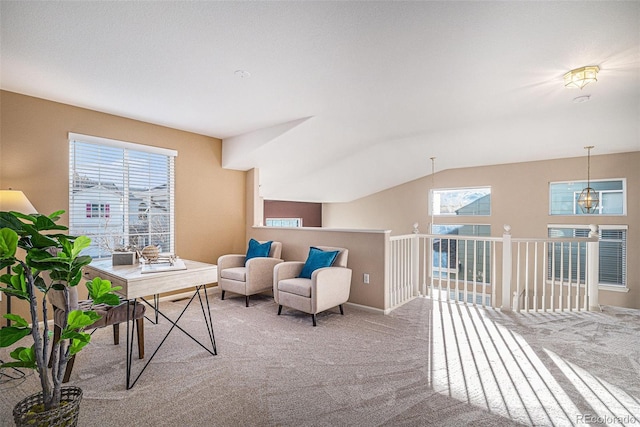 living area with plenty of natural light, vaulted ceiling, and carpet flooring