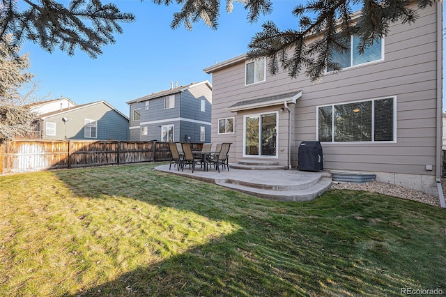 back of property with a lawn and a patio