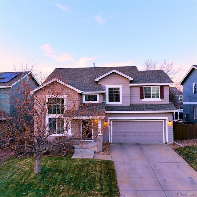 front facade with a yard and a garage