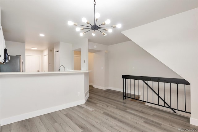 interior space with a chandelier, light hardwood / wood-style floors, and sink