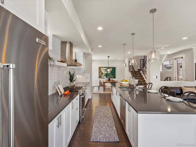 1819 Gaylord St, Denver, CO 80206 - kitchen featuring appliances with stainless steel finishes, dark countertops, wall chimney range hood, tasteful backsplash, and recessed lighting