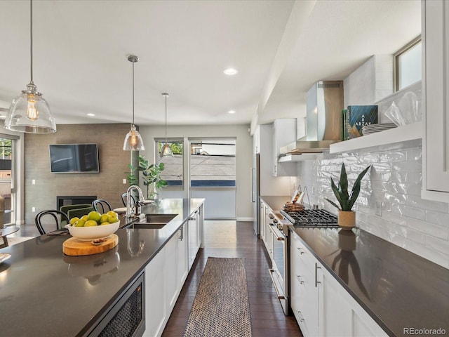 1819 Gaylord St, Denver, CO 80206 - kitchen with stainless steel appliances, wall chimney exhaust hood, dark countertops, decorative backsplash, and recessed lighting