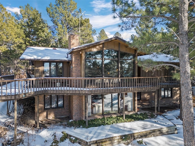 snow covered house featuring a deck