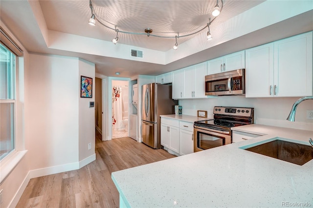 919 S Dawson Way Unit 14, Aurora, CO 80012 - kitchen with appliances with stainless steel finishes, track lighting, light wood-type flooring, and light countertops