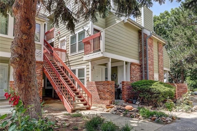 919 S Dawson Way Unit 14, Aurora, CO 80012 - view of property exterior featuring brick siding, a chimney, and stairway
