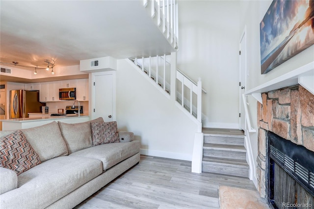 919 S Dawson Way Unit 14, Aurora, CO 80012 - living room featuring stairs, light wood-type flooring, and a fireplace